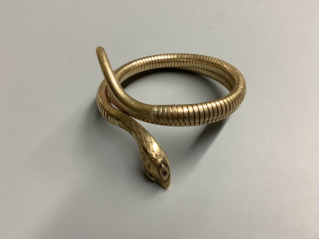 A 1960’s nine carat gold coiled serpent bracelet with ruby eyes, gross weight 30 .1 g.